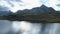 Aerial side above alpine lake revealing mountain valley in cloudy day dusk or dawn.Europe Italy Alps outdoors green