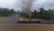 Aerial side view time lapse of a two steam locomotives double heading a freight train steaming up with black smoke and steam