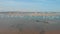 An aerial sideway right to left footage of an harbor marina with boats and a wreck ship under a majestic blue sky