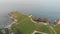 An aerial sideway right to left footage of the Lulworth Cove with sandy beach, crystal blue water, fishing boat, kayakistes and