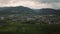 Aerial slide across small town at foot of mountains as night falls