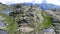 Aerial slow motion footage of female hiker exploring spectacular mountain landscape.