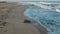 Aerial slow motion over rough white waves crashing on beach at sunrise