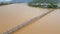 Aerial slowmotion shot of a wooden bridge across the river in Asia with motorbikes riding on it. Dangerous