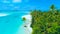 AERIAL: Small boat is stuck on the sandy shore of the lush tropical island.