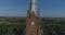 Aerial. Smooth tilt / crane drone shot of St. John church of Ramygala in Lithuania. Panorama of city in early autumn. 4k