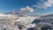 Aerial for the snowy countyside road with forest and fields surrounding. Shot. Rural winter area with road in winter