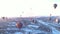 Aerial snowy valley landscape with lots of hot air balloons at the sunrise in Cappadocia