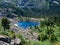 Aerial spectacular view to scenic valley with beautiful mountain forest lake, conifer forest and rocky mountains. Amazing