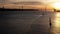 Aerial static backlit sailboats at sunset on Tagus River in Lisbon, Portugal with 25 April Bridge in the background