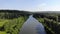 Aerial stock footage of river is located in woods in summer Sunny day