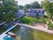 Aerial Sunny Waterfront Luxury Home with Boats and Patio