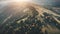 Aerial sunset mountain range. Pine tree forest, spruce, conifer treetops and yellow meadows