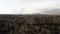 Aerial of surreal natural features of mountains on cloudy sky background. Action. Rare houses built near the picturesque