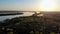 Aerial survey by drone above the forest and river at sunset