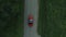 Aerial survey of red cabrioled goes on the road and couple using colored smoke.Flying over classic red convertible car