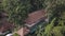 Aerial surveying bungalows with thatched roofs in tropical hotel, outdoor pool