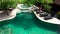 Aerial a swimming pool with chairs with umbrella in a Bali resort