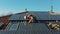 Aerial Technician with hard hat installing solar panel installed on home rooftop