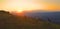 AERIAL: Three friends on outdoor adventure riding bicycles up a grassy hill.