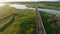 Aerial tilt up on open road and over river on coastal highway at sunrise