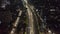 Aerial tilting shot following one police car on empty multi lane motorway at night in large metropolitan city during