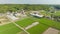 Aerial timelapse: Rise over small farm as traffic moves on country road