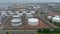 Aerial top big industrial oil tanks in a refinery industrial plant near ocean
