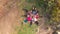 Aerial top down drone view of group people lying on grass like star, friends have good time together outdoor in spring