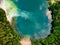 Aerial top down view of beautiful green waters of lake Gela. Birds eye view of scenic emerald lake surrounded by pine forests
