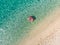 Aerial top down view of cute young girl floating on toy ring at Myrtos beach, the most beautiful beach of Kefalonia, a large coast