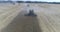 Aerial top shot of thre green harvesters harvesting on the wheat field