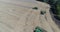 Aerial top shot of three green combines on wheat field