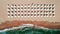 Aerial top view on the beach. Umbrellas, sand and sea waves