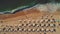 Aerial top view on the beach. Umbrellas, sand and sea waves. Summer holidays.