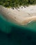 Aerial top view of beach with white sand, beautiful umbrellas and warm turquoise tropical water