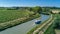 Aerial top view of boat in Canal du Midi from above, family travel by barge and vacation in France