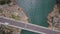 Aerial top view of a bridge crossing the blue sea and rocks. Clip. Summer marine landscape with turquoise water and