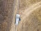 Aerial top view of the car on the road off road in countryside on a rainy day f