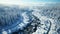 Aerial top view Curvy road in snow covered forest in winter