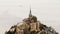 Aerial top view, drone flying above amazing Mont Saint Michel Abbey, famous island fortress town landmark in France.