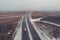 Aerial or top view from drone to winter asphalt highway or motorway road in countryside with cargo logistic trucks traffic