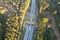 Aerial top view of an ecoduct highway with traffic surrounded by green forests under the sunlight