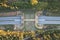 Aerial top view of an ecoduct highway with traffic surrounded by green and yellow trees