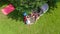 Aerial top view of family in campsite from above, parents and kids relax and have fun in park, tent and camping equipment