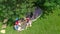 Aerial top view of family in campsite from above, parents and kids relax and have fun in park, tent and camping equipment