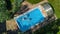 Aerial top view of family in swimming pool from above, happy mother and kids swim on inflatable ring donuts and have fun in water