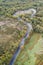 Aerial top view of forest road in beautiful autumn at sunset. Curved road in the mountains with nice landscape