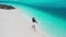 Aerial top view of happy woman walking water on white sand beach with turquoise ocean at Fulidhoo island in Maldives.