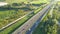 Aerial top view of highway road. Drone view of the elevated road, traffic junctions, and green garden. Transport trucks and cars